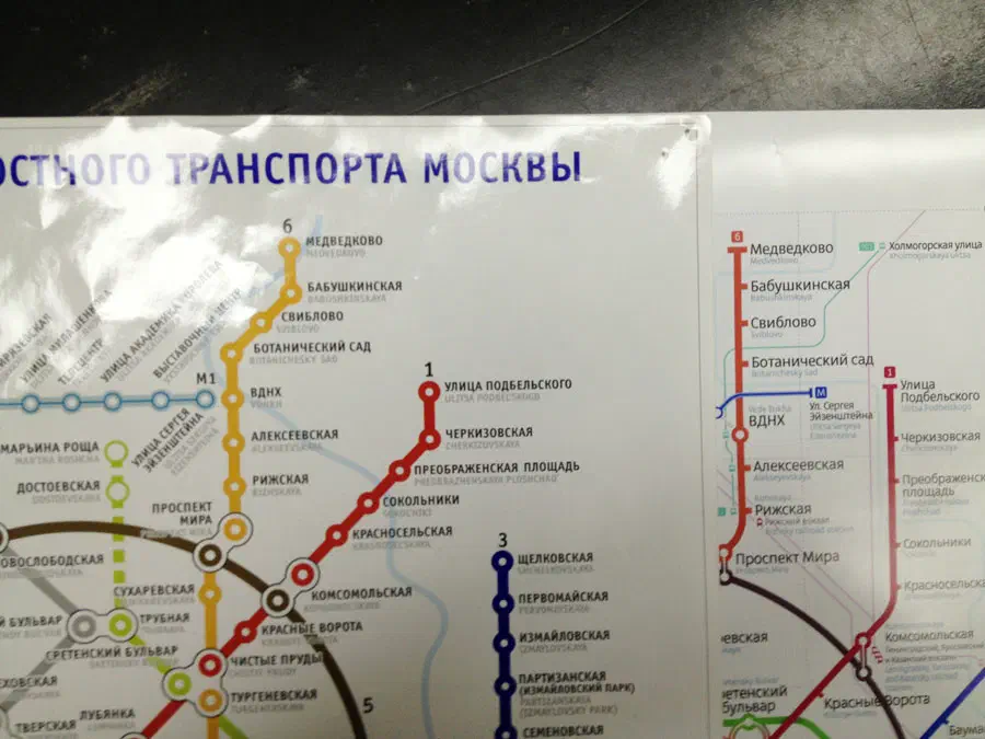 Карта показывает на столе карту московской системы метро, которая представляет собой детальную карту системы метро с текстом, указывающим различные остановки и маршруты города.