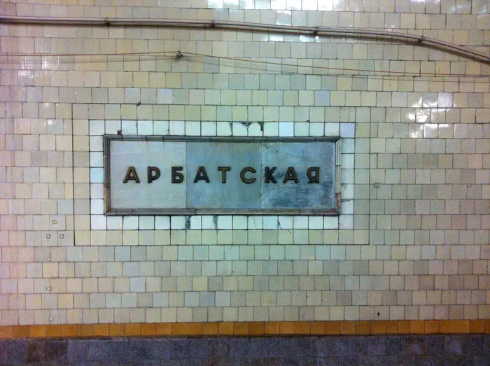 Изображение показывает станцию метро со знаком на стене, который читается "Areebabcckay", и доску с текстом на ней, а также трубу, протекающую вдоль