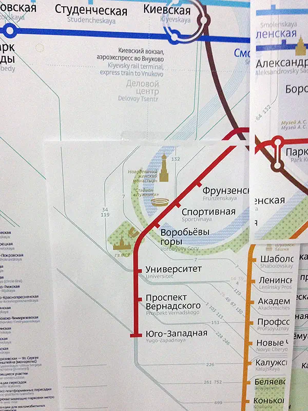 Карта показывает близость карты на стене с красной линией, проходящей через нее. Карта представляет собой детальную карту маршрута московской системы метро с текстом, указывающим различные остановки и маршруты метро.