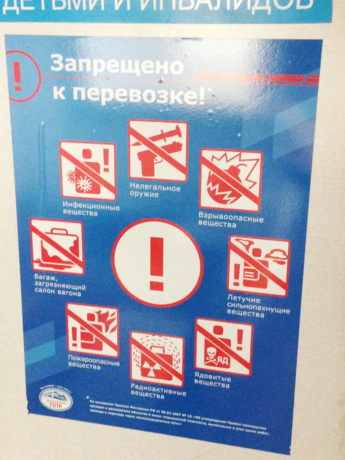 Изображение показывает плакат на стене здания с надписью "Нет курить" жирным, черным шрифтом. Этот плакат ярко окрашен желтым фоном и красным и синим текстом.