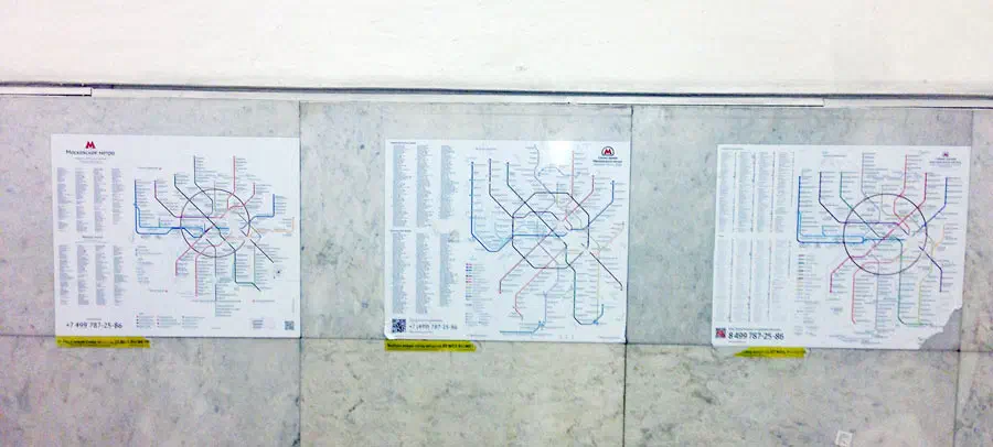 На снимке изображены три плаката на стене станции метро с тремя различными типами приложенных к ней карт. Эти плакаты яркие и содержат подробную информацию о системе метро, такую, как названия станций,