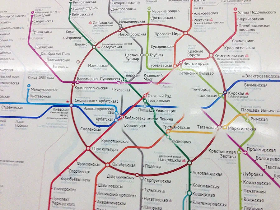 Карта показывает карту московской системы метро на белой стене, которая является подробной картой с различными линиями и текстом, указывающей различные остановки и маршруты системы метро.