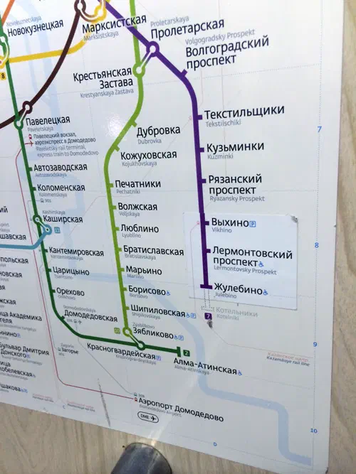 На снимке изображен плакат на стене станции метро в Москве, Россия, с ножкой человека, видимой внизу изображения.
