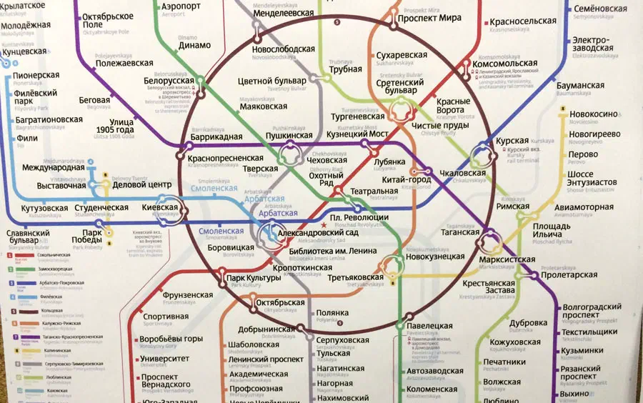 Карта показывает карту московской системы метро на стене. Она является детальной картой с различными линиями и текстом, указывающей различные остановки и маршруты системы метро. Карта заполнена яркими цветами и символами.