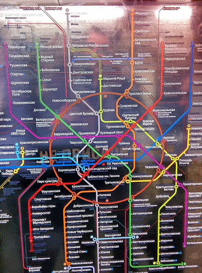 На снимке изображена постер-карта метро на стене Московской Метро. Карта заполнена красочными линиями и текстом, содержащими подробную информацию о различных остановках и маршрутах системы метро.