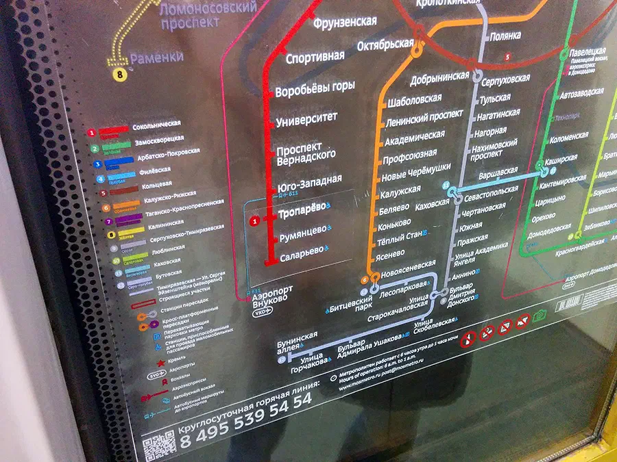 Карта показывает карту метро на боковой стороне поезда с текстом и указаниями на экране. Карта, вероятно, из московского метро, содержит информацию о различных остановках и маршрутах системы метро.