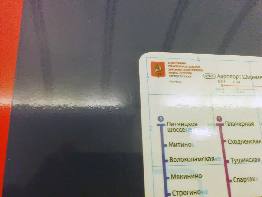 Изображение показывает, что на стене рядом стоит знак с картой. Знак - это бумага с текстом и логотипом, а фон - стена.