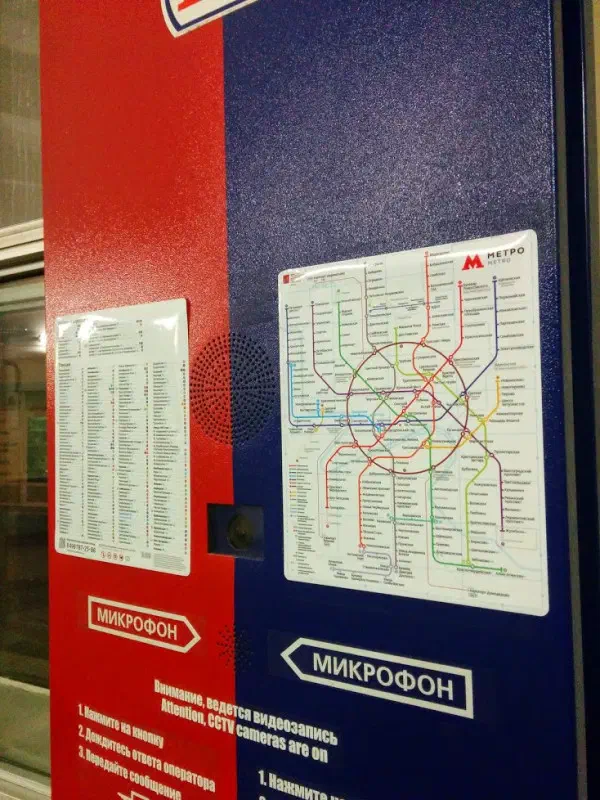 На снимке изображена красная и синяя дверь с картой московской системы метро, а также несколько бумаг на ней и стеклянное окно на левой стороне.