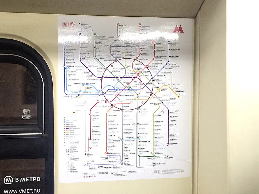 Карта показывает карту метро на стене станции метро с плакатом с картой, прикрепленной к стене, и окном с левой стороны.