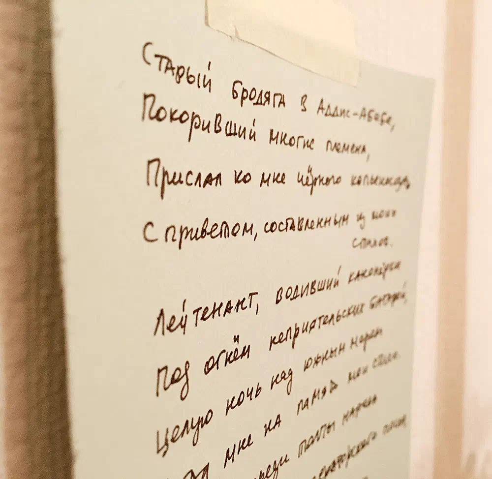 Изображение показывает клочок бумаги с надписью, прикрепленной к стене. Эта бумага, похоже, является буквой, написанной на русском языке, а текст написан черными чернилами на белом фоне.