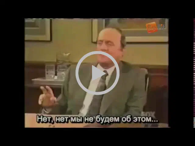 На рисунке изображен человек в костюме и галстуке, сидящий за столом со стаканом воды перед ним.
